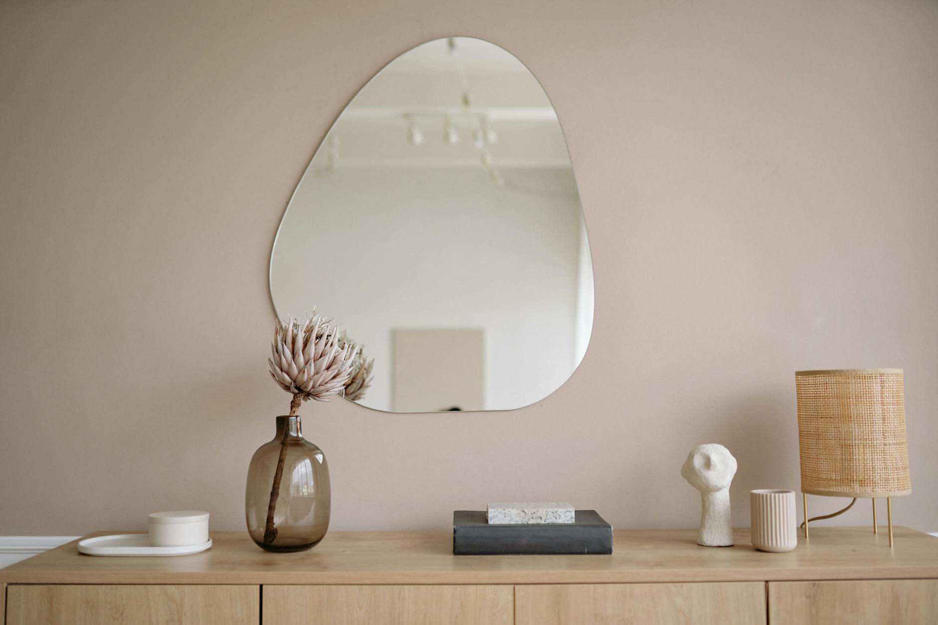 a mirror wall above a cabinet